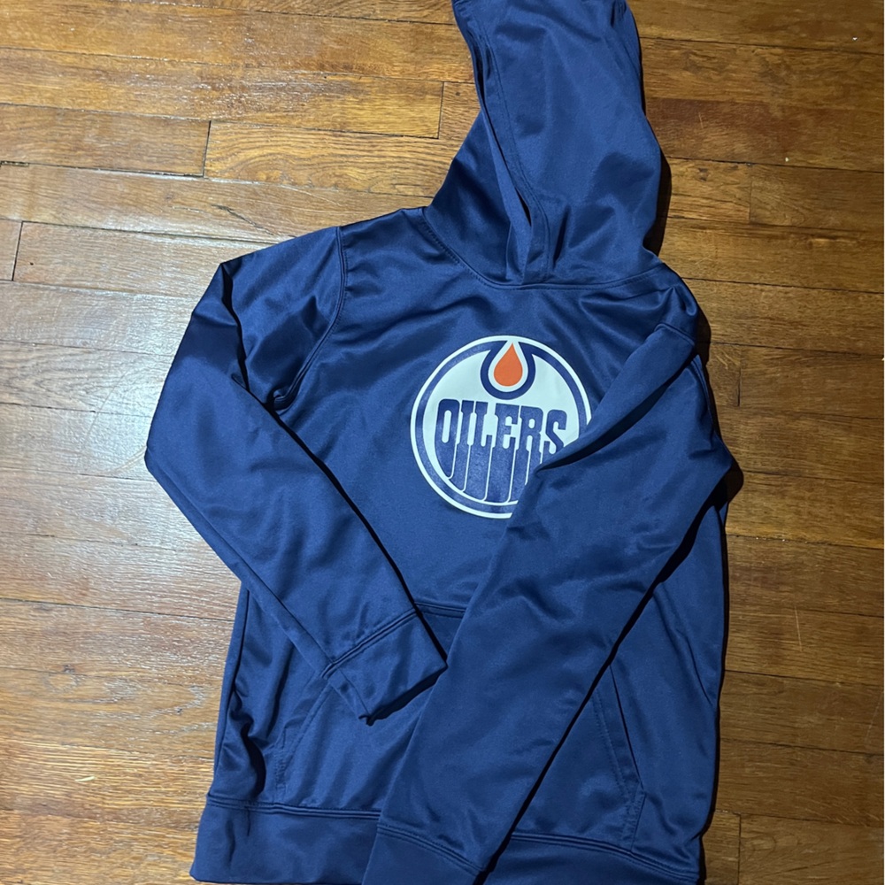 This is a navy blue Edmonton Oilers hoodie. Youth 10/12